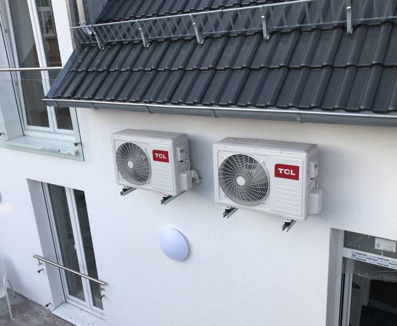 Zwei TCL Außengeräte an einer Hausfassade wandmontiert